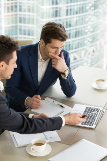 Two businessman working on a computer